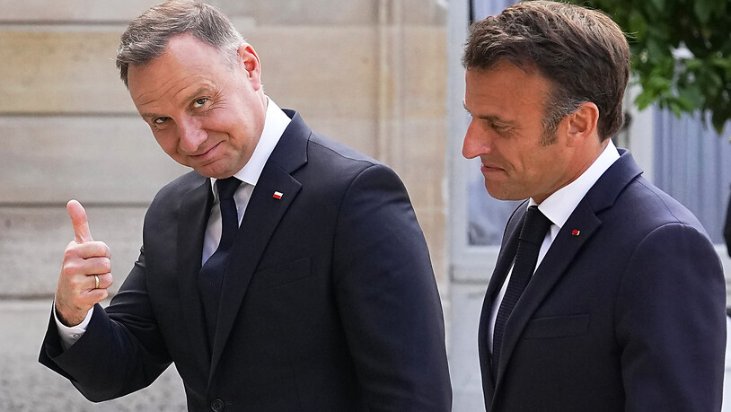 Emmanuel Macron (r), Präsident von Frankreich, reagiert auf den Daumen von Andrzej Duda, Präsident von Polen, im Elysee-Palast. Der französische Präsident Macron empfängt Bundeskanzler Scholz und den polnischen Staatschef Duda zu einem Dreier-Gipfel. Im…