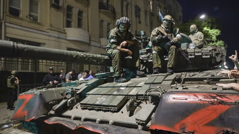 Angehörige des Militärunternehmens Wagner Group sitzen auf einem Panzer auf einer Straße in Rostow am Don, Russland, bevor sie einen Bereich im Hauptquartier des südlichen Militärbezirks verlassen. Foto: -/AP/dpa