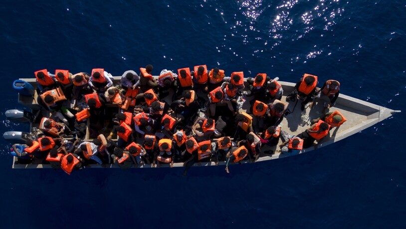 dpatopbilder - Menschen aus Eritrea, Libyen und dem Sudan warten in einem Holzboot auf die Helfer einer spanischen Nichtregierungsorganisation. Foto: Joan Mateu Parra/AP/dpa