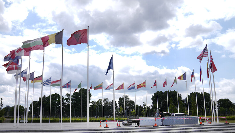 Ein Mann führt Bauarbeiten rund um die Flaggen im Nato-Hauptquartier durch. Die Nato bereitet für den bevorstehenden Gipfel in Litauen ein umfassendes Unterstützungspaket für die Ukraine vor. Foto: Virginia Mayo/AP/dpa