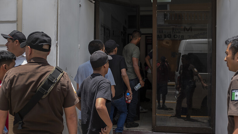 HANDOUT - Migranten, die aus einem abgestellten Lastwagen befreit wurden, werden in ein Büro des mexikanischen Instituts für Migration gebracht. Foto: Felix Marquez/dpa