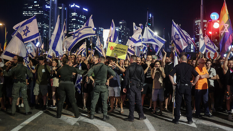 Polizisten stehen vor Demonstranten während eines Protests in Tel Aviv gegen die israelische Regierung. Foto: Ilia Yefimovich/dpa