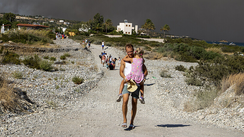 dpatopbilder - Nach der Evakuierung vieler Dörfer und Hotelanlagen wegen großer Waldbrände haben viele Menschen auf Rhodos die Nacht im Freien verbracht. Foto: Lefteris Damianidis/InTime News/AP/dpa