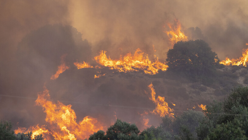 Am Mittag ist Nahe der Ortschaft Gennadi ein neuer Waldbrand ausgebrochen, am Abend erreichen die Flammen eine erste Siedlung, mehrere Häuser werden zerstört. Foto: Christoph Reichwein/dpa