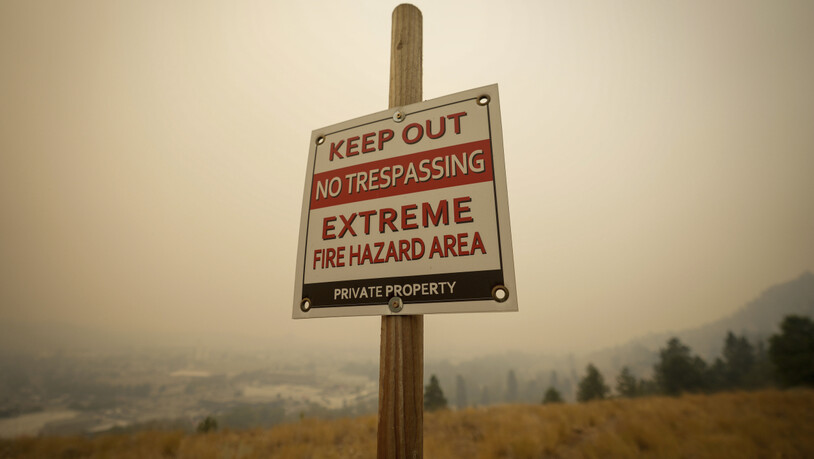 In Kelowna, British Columbia, steht ein Warnschild, das vor der Brandgefahr warnt, während Rauch von Waldbränden die Luft füllt. Foto: Darryl Dyck/The Canadian Press via AP/dpa - ACHTUNG: Nur zur redaktionellen Verwendung und nur mit vollständiger…