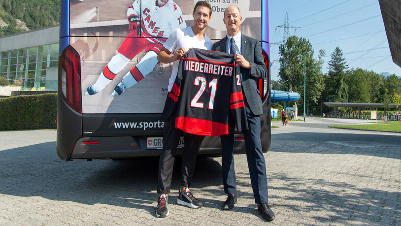 Stadtpräsident Urs Marti mit Bus, Eishockey-Profi und Trikot.