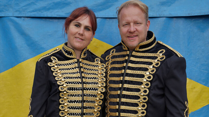 Halten zusammen: Die beiden Zirkusdirektoren und Gründer Ramona und Marco Berger stehen in Uniform vor ihrem Zirkuszelt. (Aufnahme vom 2021)