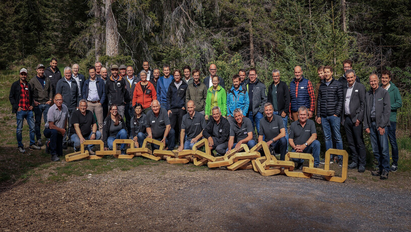 Mehrdeutige Symbolik: die Teilnehmenden der GV als Vertreter der Holzkette Graubünden mit Arvenholzkette.