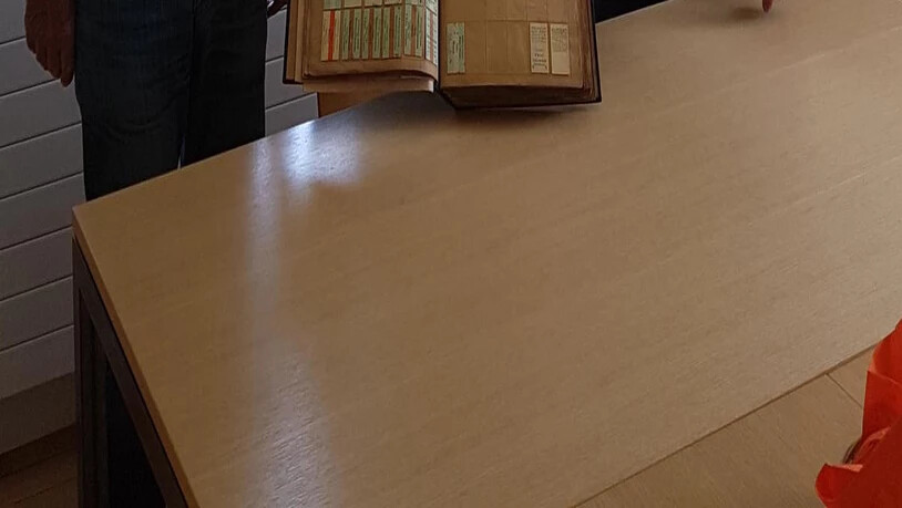 Stiftungsrat Gion Caprez, im Bahnmuseum für die Sammlung und das Archiv verantwortlich, freut sich mit zwei der Gönner über das neu restaurierte Billet-Musterbuch aus dem Jahr 1898.