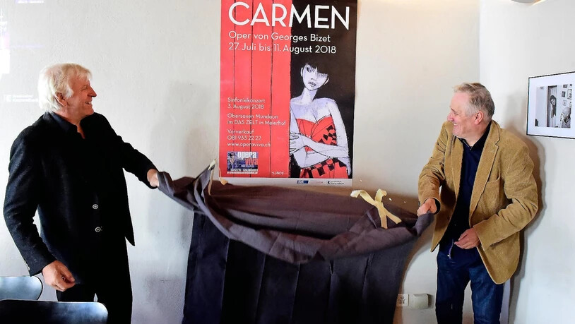Gion Gieri Tuor und Andrea Zogg enthüllen das Plakat von Rudolf Mirer.
