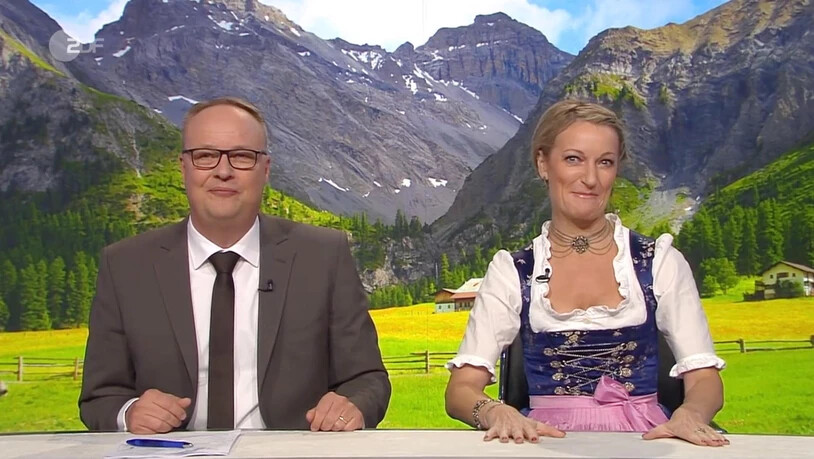 Oliver Welke und Monika Gruber erörtern die Heimatliebe in der deutschen Politik – vor dem Hintergrundbild aus dem Sertigtal.