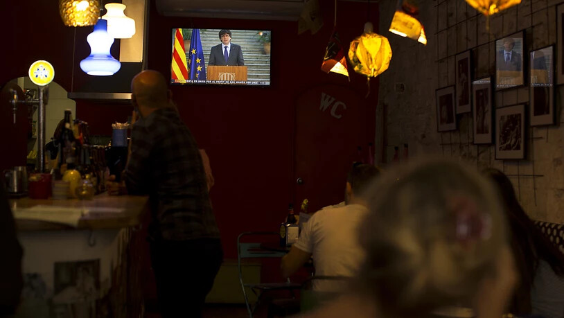 Barbesucher hören sich Puigdemonts Fernsehrede an. In den spanischen Medien wurde die Rede so interpretiert, dass er der Amtsenthebung nicht Folge leisten wolle.