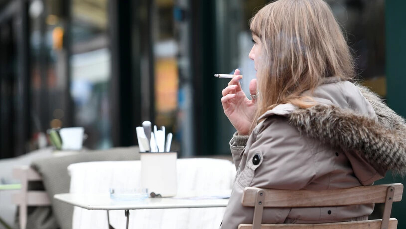 Frau mit Zigarette vor einem Restaurant in Wien.
