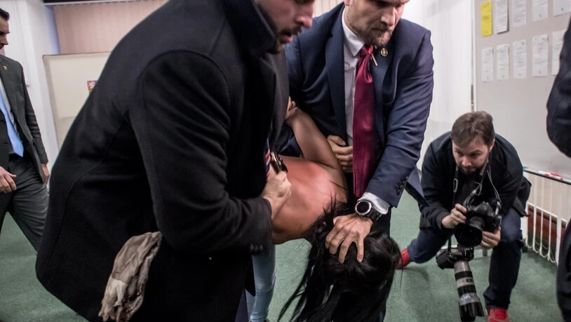 Leibwächter überwältigen die Femen-Aktivistin nach ihrer physischen Attacke auf Tschechiens Präsident Milos Zeman in einem Wahllokal. (Archivbild)