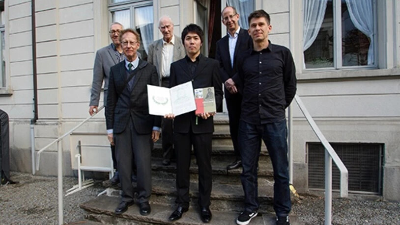 Oswald-Heer-Preisträger Amane Tajika mit der Preisurkunde, mit seinen Kollegen Conradin Burga (l.) und Christian Klug (zweite Reihe v.l.), sowie Rektor Peter Aebli, Vertreter der Walters/Wild-Stiftung, René Hantke und Fridolin Marti, Präsident der NGG.