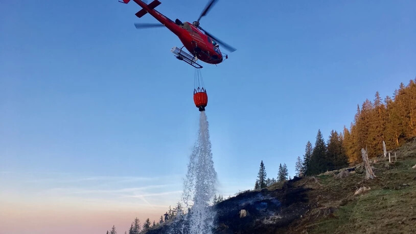 Löschen mit Wasser aus dem Gantrischsee: Ein Helikopter bekämpft den Waldbrand in Blumenstein.