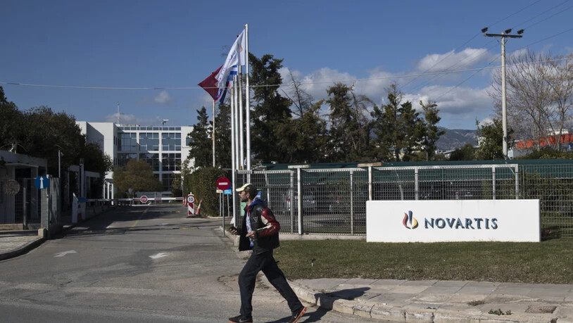 Ein Mann überquert vor der Novartis-Niederlassung in Athen eine Strasse. Dem Basler Pharmakonzern wird vorgeworfen, in Griechenland Ärzte und Politiker bestochen zu haben. (Archiv)