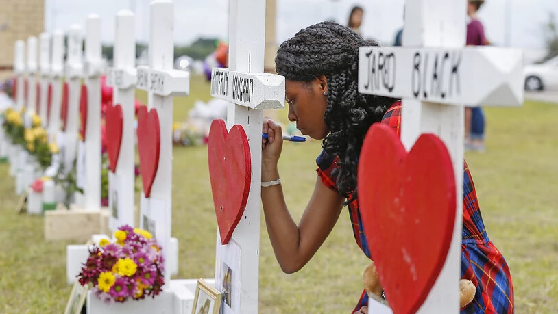 Eine Schülerin der Santa Fe High School schreibt eine Botschaft für ihre erschossenen Mitschüler. Der 17-jährige Amokläufer kannte alle seine Opfer.  (Foto: Steve Gonzales/Houston Chronicle via AP)