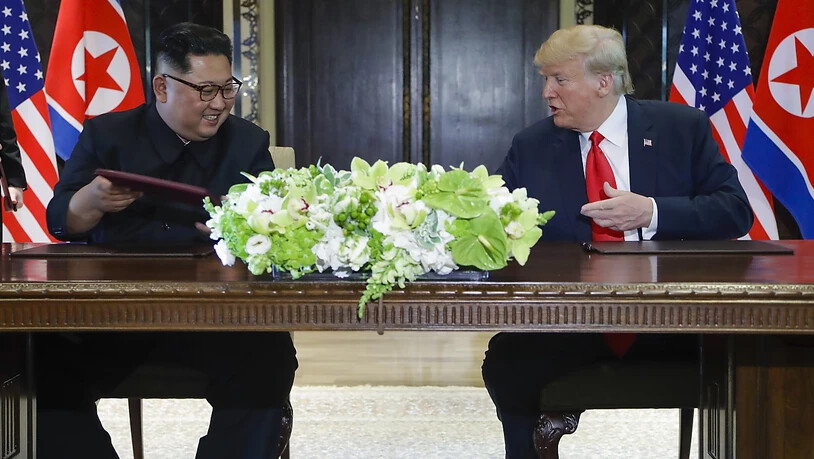 Kim Jong Un (links) und US-Präsident Donald Trump tauschen die unterzeichneten Dokumente aus.