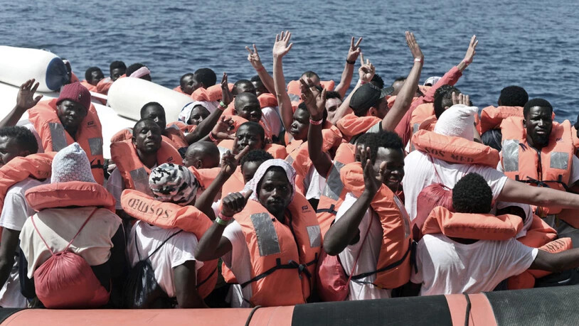 Flüchtlinge von der "Aquarius" winken, nachdem sie auf ein Boot der italienischen Küstenwache gebracht wurden.