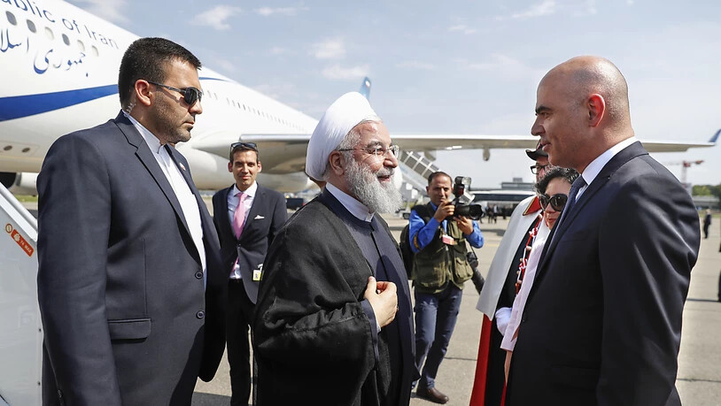 Bundespräsident Alain Berset (rechts) begrüsst seinen iranischen Amtskollegen Hassan Ruhani (Mitte) nach dessen Ankunft am Nachmittag in Zürich-Kloten.