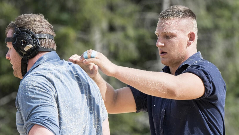 Sieger Lario Kramer (rechts) befreit den unterlegenen Schwingerkönig Matthias Glarner vom Sägemehl