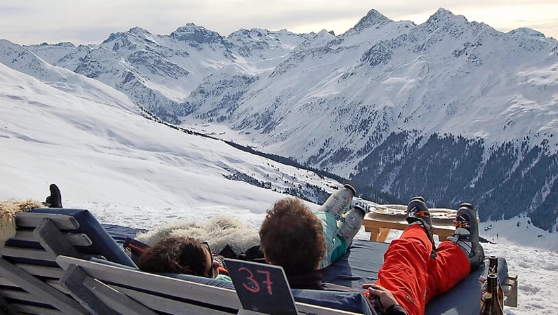 Schneesportler geniessen auf dem Davoser Jakobshorn einen Apéro mit Aussicht.