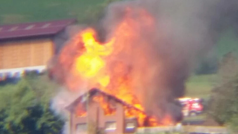 Das brennende Haus durch einen Feldstecher fotografiert.