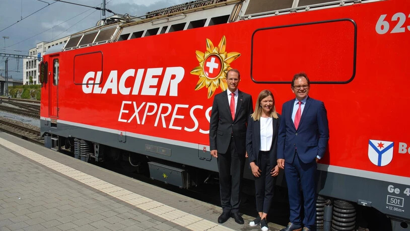 Renato Fasciati, (RhB), Annemarie Meyer (Glacier Express AG) und Fernando Lehner (MGBahn) freuen sich über die neue Lok.