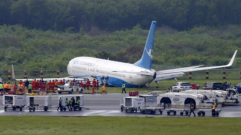 Über die Landebahn hinaus gerutscht: Die Maschine der chinesischen Fluggesellschaft Xiamen Airlines liegt nach der missglückten Landung neben der Piste im Gras.