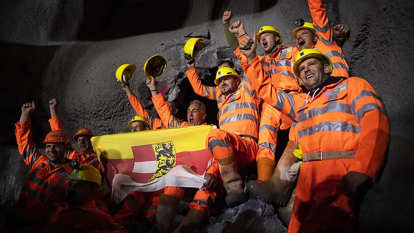 Es ist vollbracht: Mineure mit der Fahne des österreichischen Bundeslandes Kärnten feiern den Durchstich des neuen sechs Kilometer langen Albulatunnels der Rhätischen Bahn ins Engadin.
