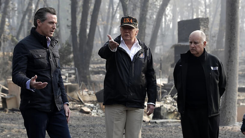 US-Präsident Donald Trump (Mitte) wurde bei seinem Besuch im Waldbrandgebiet vom scheidenden Gouverneur des Bundesstaates, Jerry Brown (r.), sowie dessen Nachfolger Gavin Newsom (l.) begleitet.