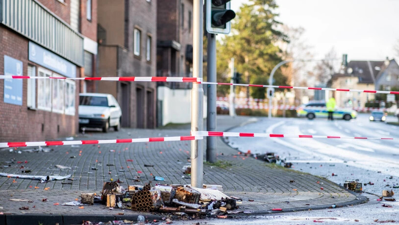 Ein Absperrband der Polizei sperrt in  Bottrop einen Teil der Osterfelder Strasse ab. Auf dem Boden liegen verbrannte Feuerwerkskörper. Ein Autofahrer hatte in der Silvesternacht seinen Wagen gezielt in eine Fussgängergruppe gesteuert und mindestens vier…