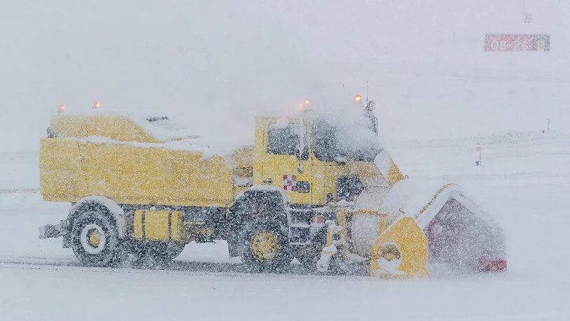 Auf dem österreichischen Flughafen in Innsbruck muss eine Schneefräse das Flugfeld bearbeiten.