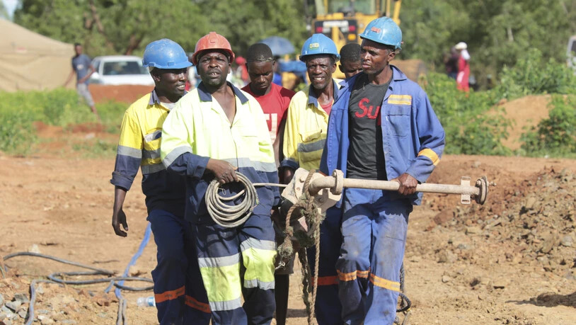 Minenarbeiter mit schwerem Gerät auf dem Weg zur überfluteten Goldmine in Simbabwe, in der dutzende illegal tätige Goldschürfer ums Leben gekommen sein dürften.