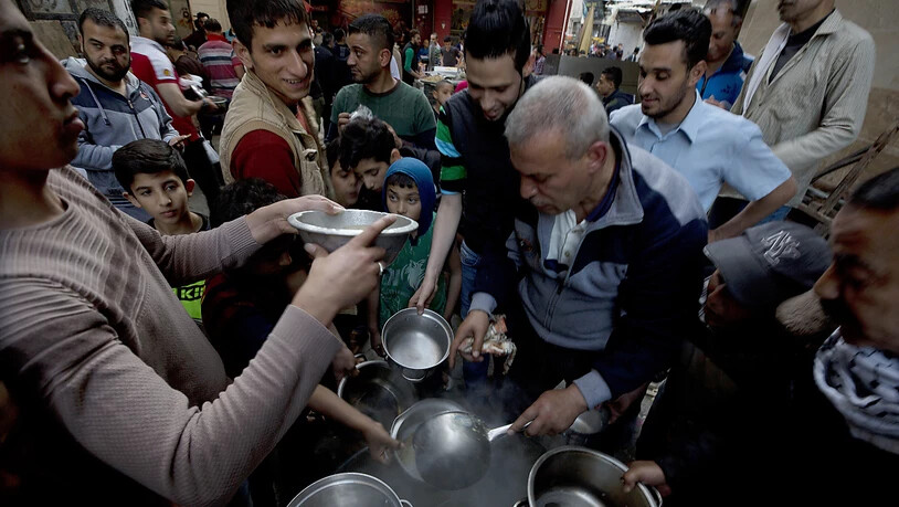 Essensausgabe durch eine Hilfsorganisation in Gaza Stadt zum Fastenbrechen während des Ramadan.