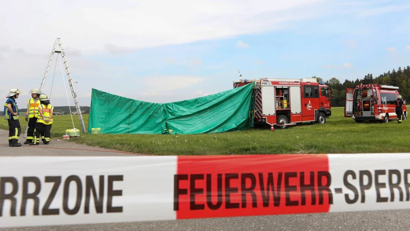 Feuerwehrleute haben auf dem Flugplatz von Bad Saulgau im deutschen Bundesland Baden-Württemberg einen Sichtschutz an der Unfallstelle errichtet. Am Morgen sind dort zwei Fallschirmspringer bei einem Sprung tödlich verletzt worden.