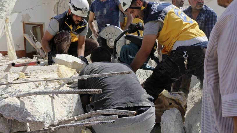 Rettungskräfte der Organisation Weisshelme suchen unter den Trümmern eines durch Luftangriffe zerstörten Gebäudes in Idlib nach Opfern.