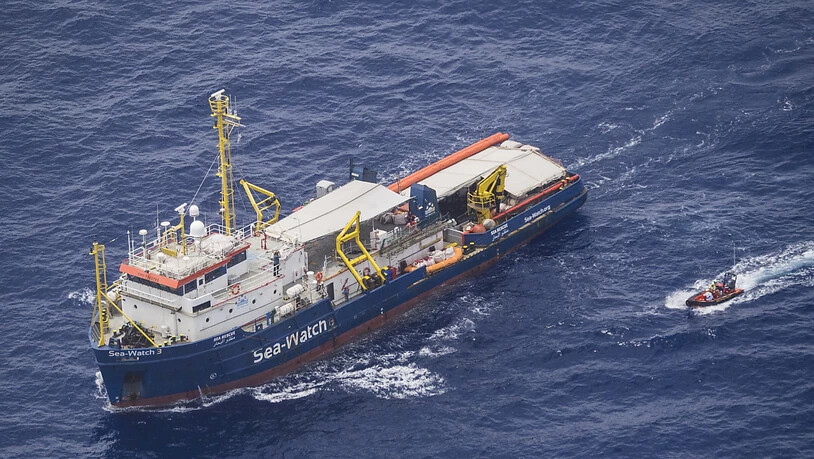 Ein Boot holt zwei Flüchtlinge vom Rettungsschiff Sea Watch 3, das vor Lampedusa blockiert ist.