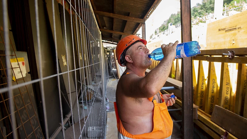 Viel trinken: Ein Arbeiter auf einer Strassenbaustelle im Tessin versorgt sich mit Wasser.