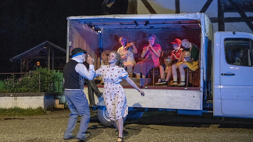 Ein Spielmann mit Maske tanzt mit Vreneli - die Musikanten fahren auf dem Ballenberg ganz modern per Lieferwagen auf.
