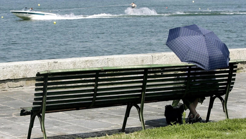 Regenschirm wird Sonnenschirm: Passantin am Genferseeufer. (Archivbild)