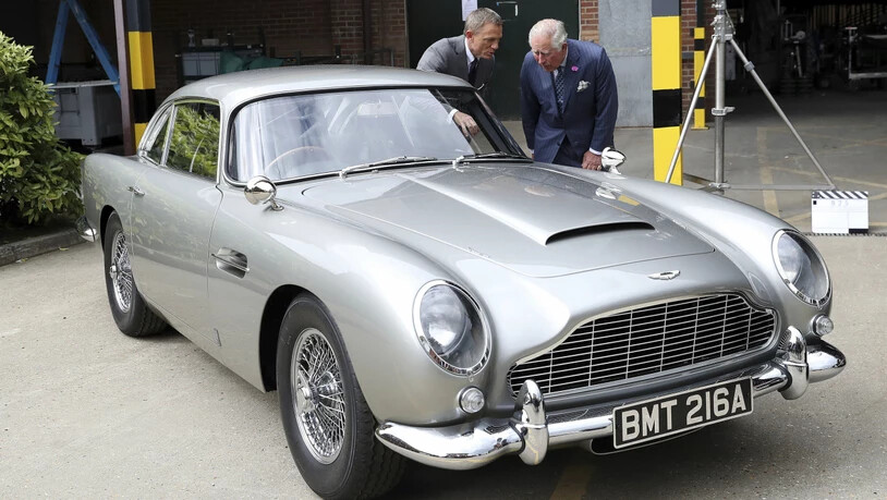 Schauspieler Daniel Craig und Prinz Charles freuen sich am Aston Martin "Bond-Auto" - weniger Freude haben derzeit allerdings die Aktionäre des Autoherstellers an ihren Papieren. (Archivbild)