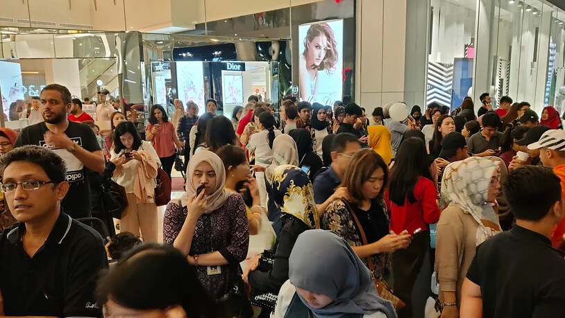 Ins Freie gerannt: Menschen stehen ausserhalb einer Shopping Mall in Jakarta.