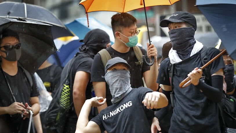 Ein Protestierender bereitet sich auf einen Eierwurf vor. Am Freitagabend und am Samstag sind in Hongkong wiederum Zehntausende auf die Strasse gegangen.