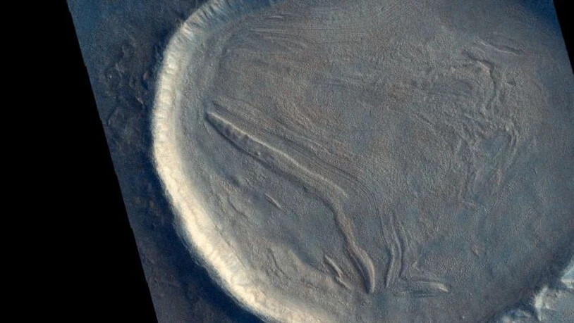Dieser unbenannte Krater auf dem Mars ist mit Material gefüllt, das "faltig" aussieht. Dies deutet darauf hin, dass das Material einmal hierhin geflossen ist und wahrscheinlich eine Mischung aus Gestein, Eis oder Frost und anderen Bodenablagerungen…