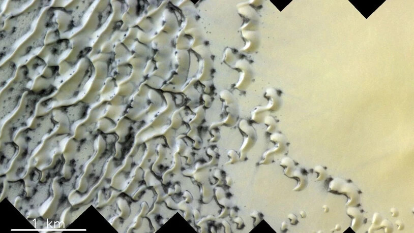 Gasausbrüche beim Auftauen von Eis erzeugen die dunklen Stellen in diesem Dünenfeld am Nordpol auf dem Mars.