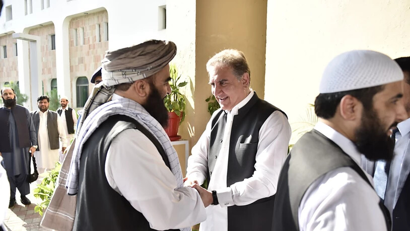 Händeschütteln und Umarmungen für die Taliban: Pakistans Aussenminister Shah Mehmood Qureshi (Mitte) beim Begrüssen der Delegation in Islamabad.