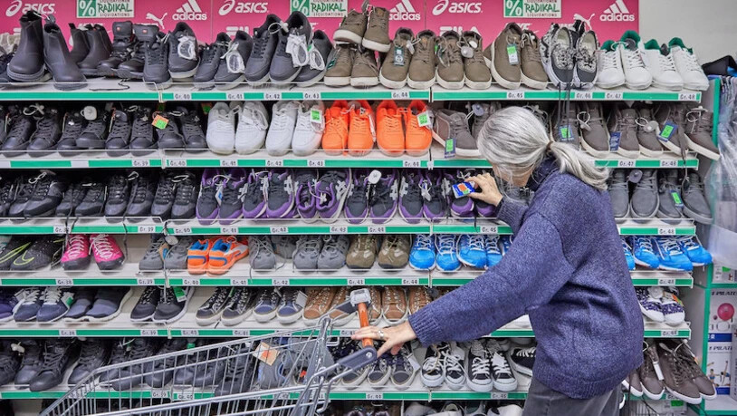 Wer auf Sozialhilfe angewiesen ist, muss jeden Franken zweimal umdrehen: Eine ältere Frau schaut sich bei einem Discounter Schuhe aus Restposten an. 