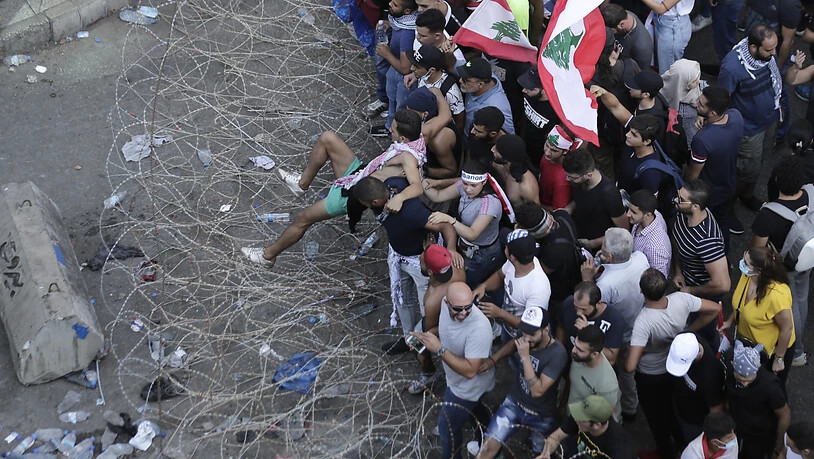 Anti-Regierungs-Demonstranten versuchen in Beirut Stacheldraht zu überwinden und zum Regierungspalast vorzudringen.